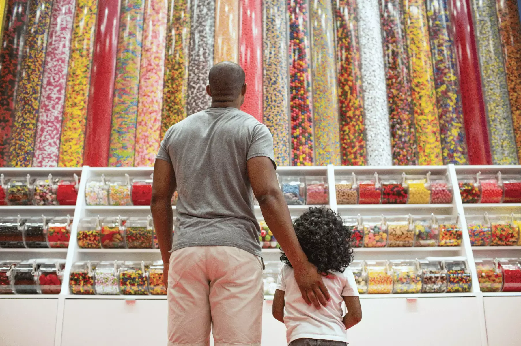 father and daughter looking at candy wall