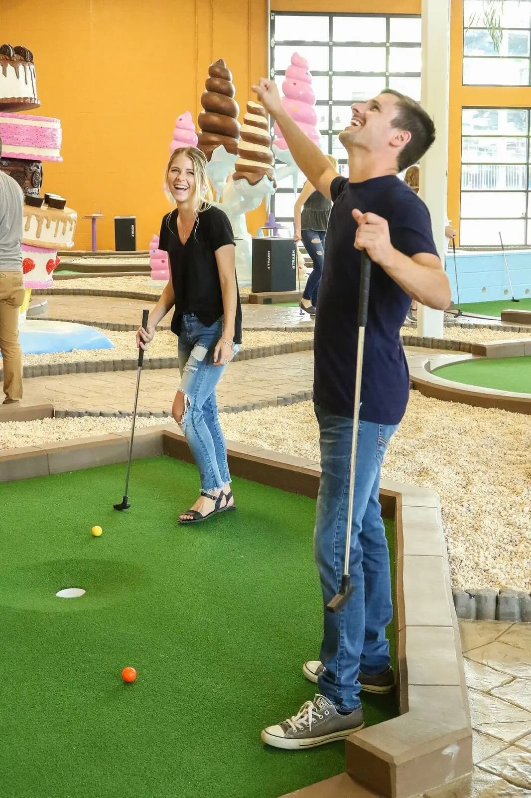 Blog - Couple smiling inside Crave Golf's indoor course