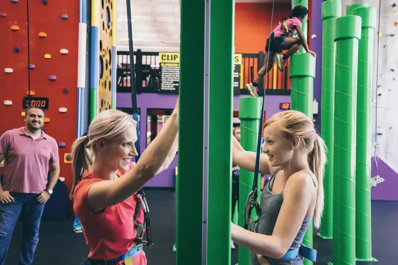 mother and daughter climbing wall while facing each other