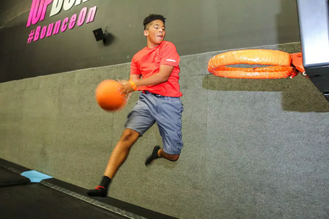 dunking basketball on trampoline
